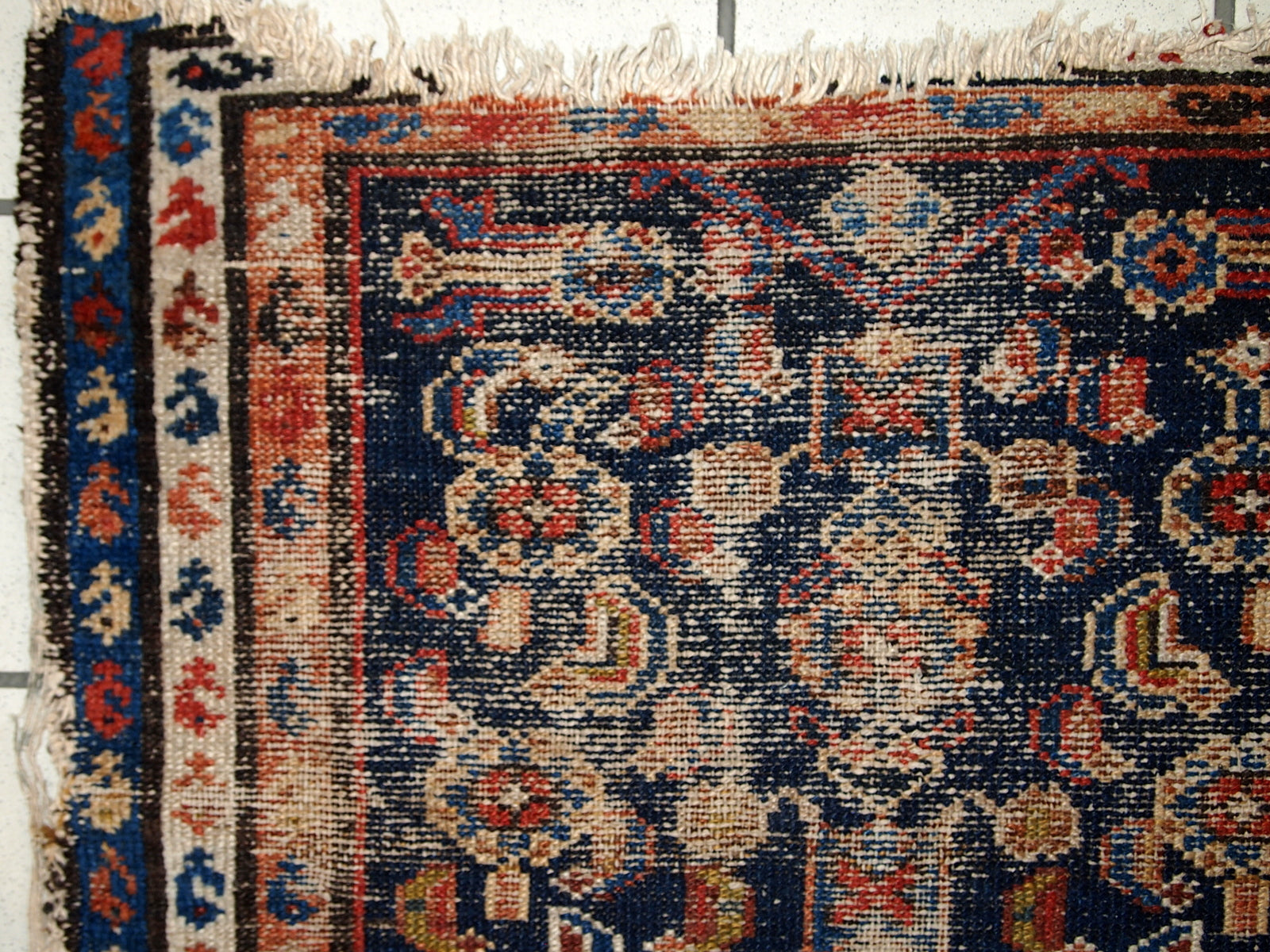 Handmade antique Middle Eastern rug in traditional design. The rug is from the beginning of 20th century in distressed condition. 