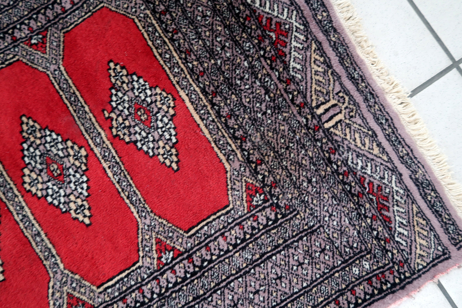 Handmade vintage Uzbek Bukhara rug in traditional design. The rug is from the end of 20th century in original good condition