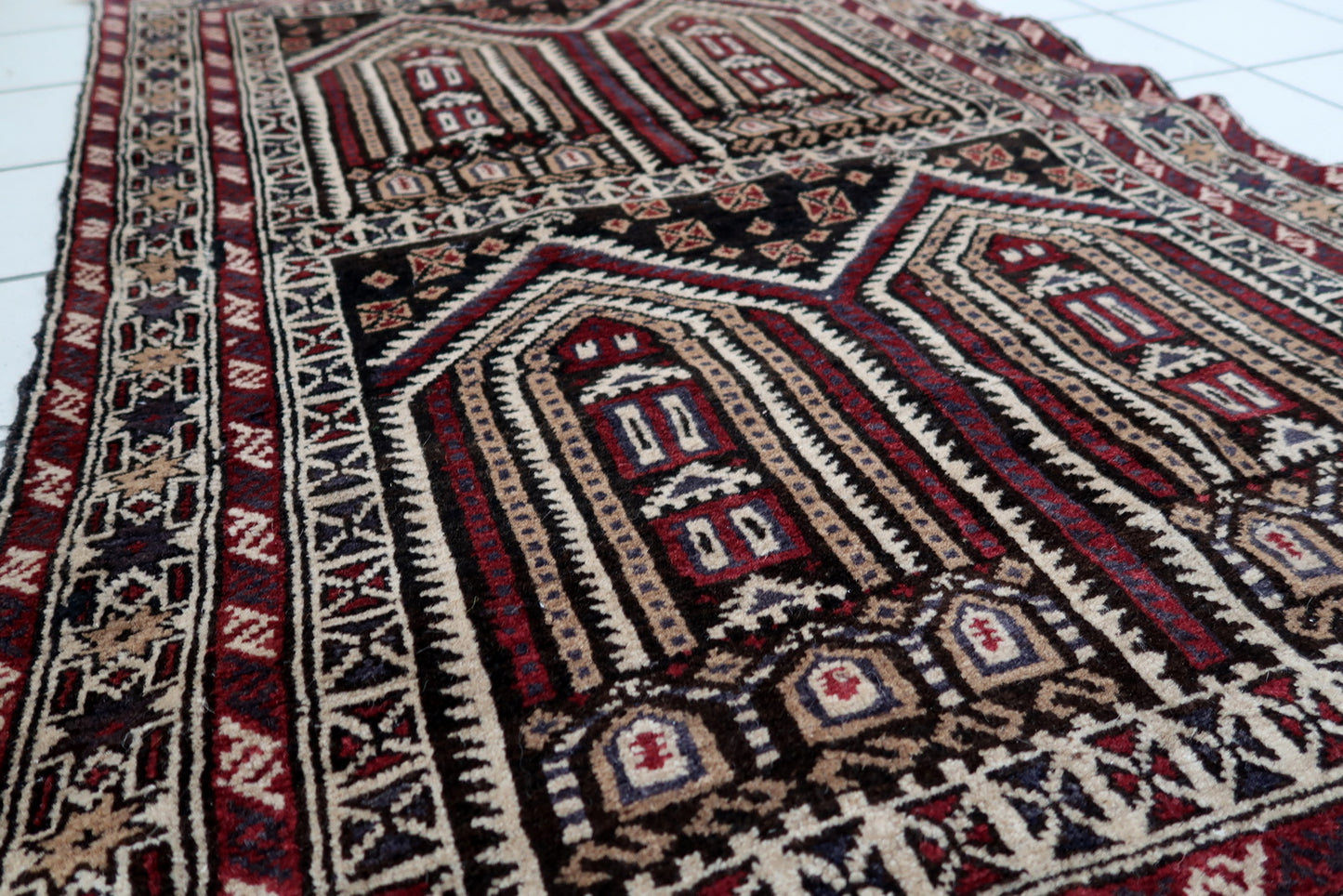 Handmade vintage Afghan Baluch rug in unusual multi-praying design. The rug is from the end of 20th century made in wool.