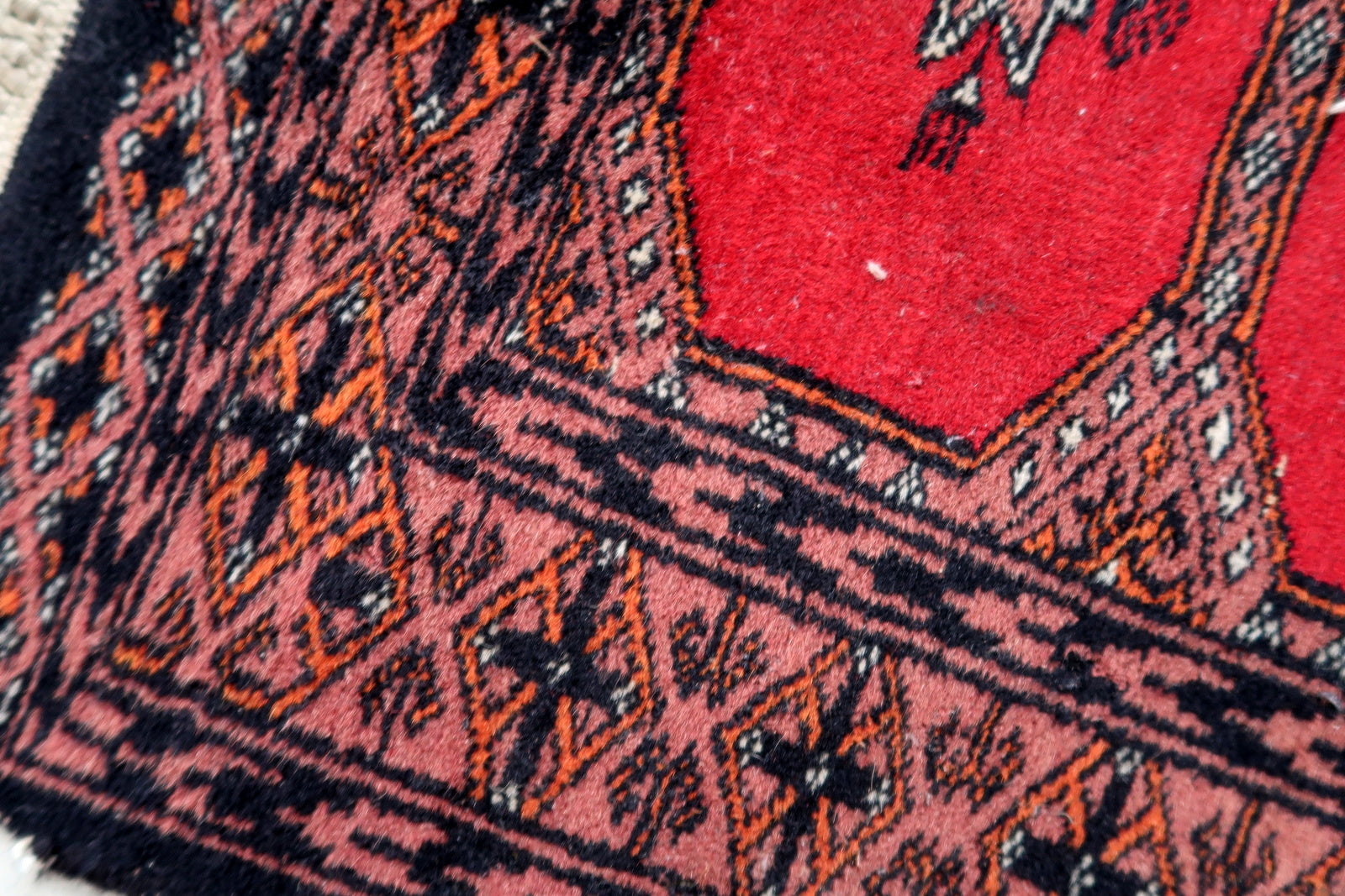 Handmade vintage Uzbek Bukhara rug in traditional design. The rug is from the end of 20th century made in wool.