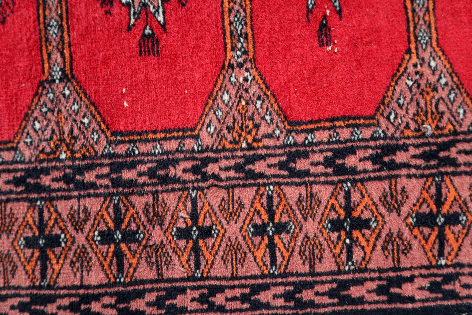 Handmade vintage Uzbek Bukhara rug in traditional design. The rug is from the end of 20th century made in wool.