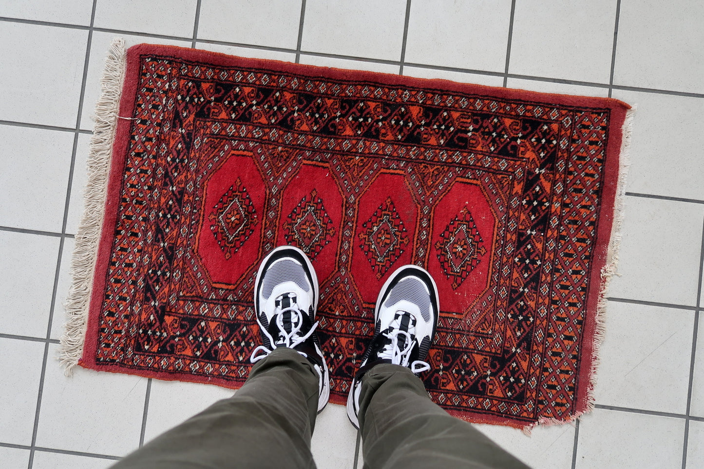 Handmade vintage Uzbek Bukhara rug in traditional design. The rug is from the end of 20th century made in wool. The rug is in original good condition, one corner has been damaged.