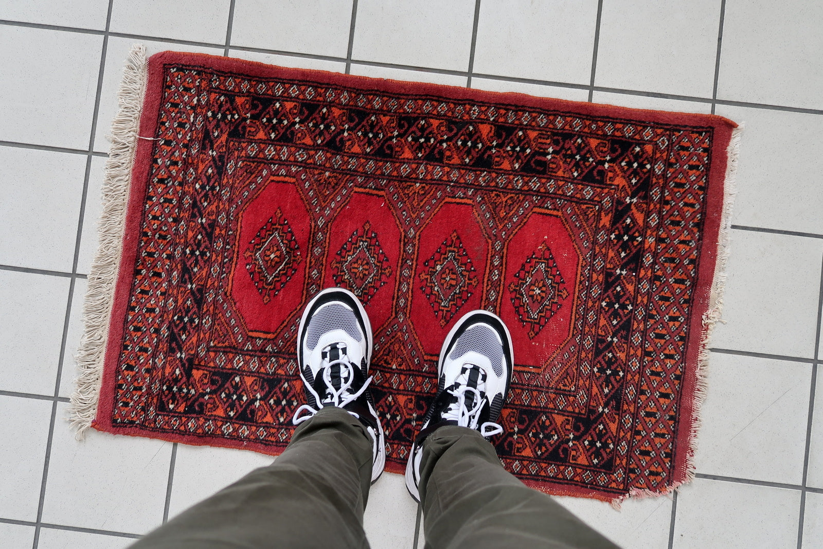 Handmade vintage Uzbek Bukhara rug in traditional design. The rug is from the end of 20th century made in wool. The rug is in original good condition, one corner has been damaged.