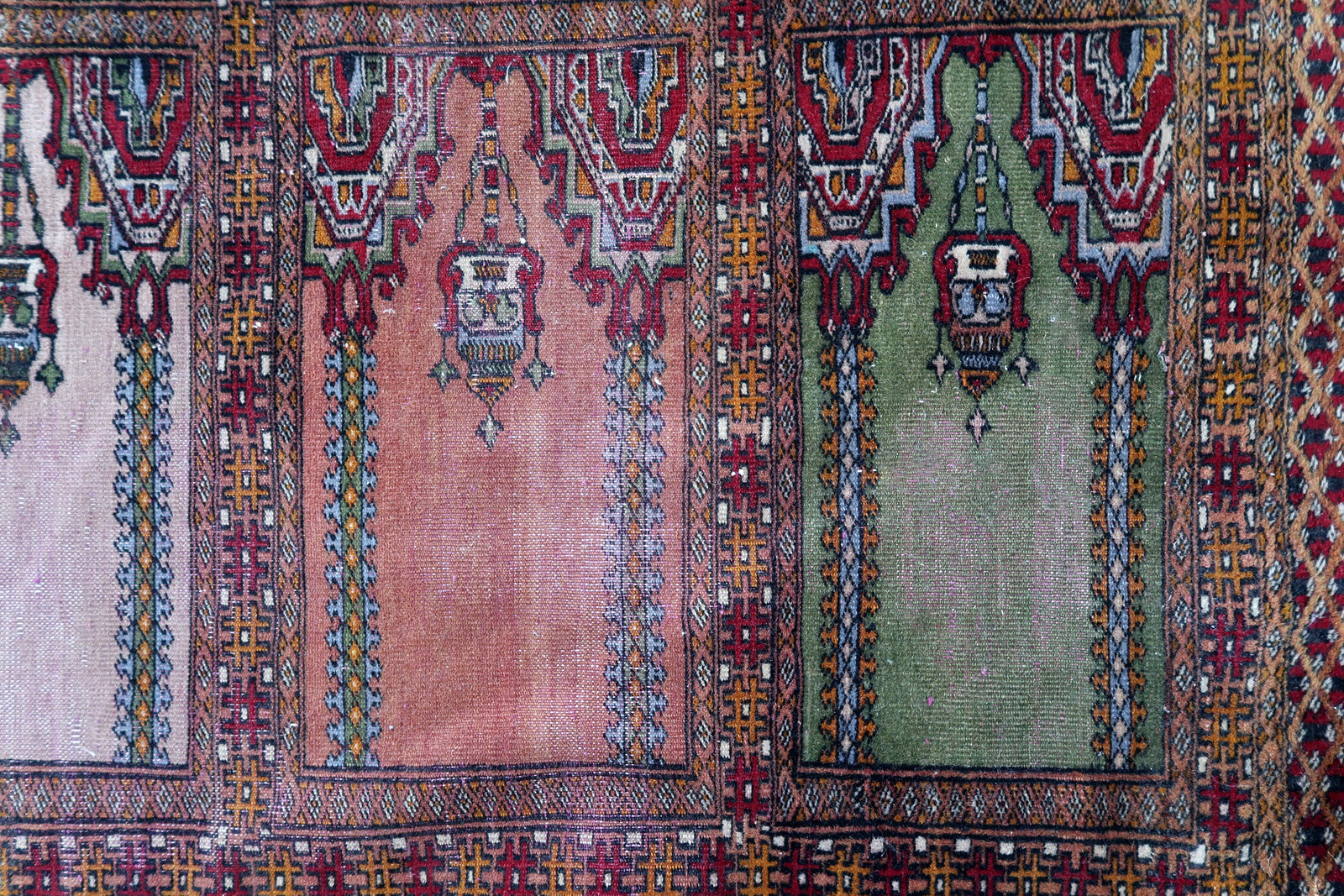 Handmade vintage Uzbek Bukhara rug in prayer design. The rug is from the middle of 20th century made in wool. The rug is in original condition, has some low pile