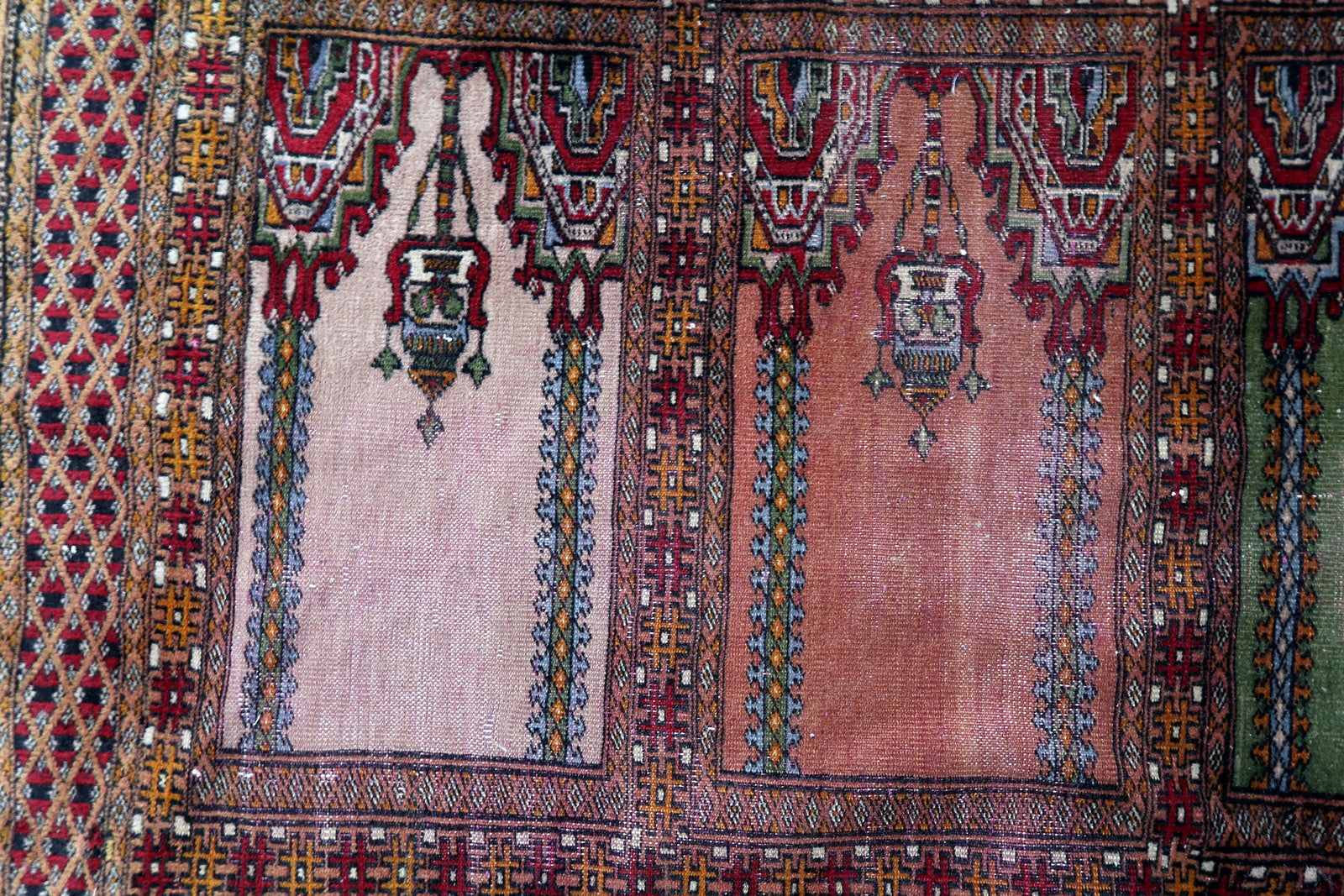 Handmade vintage Uzbek Bukhara rug in prayer design. The rug is from the middle of 20th century made in wool. The rug is in original condition, has some low pile