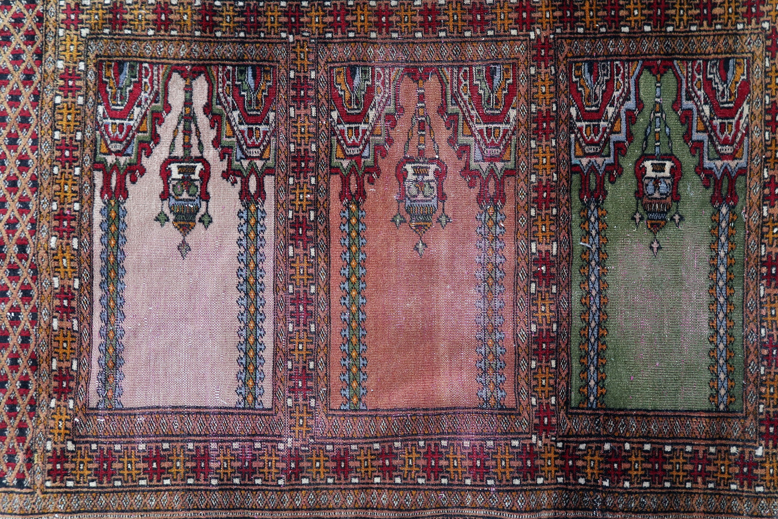 Handmade vintage Uzbek Bukhara rug in prayer design. The rug is from the middle of 20th century made in wool. The rug is in original condition, has some low pile