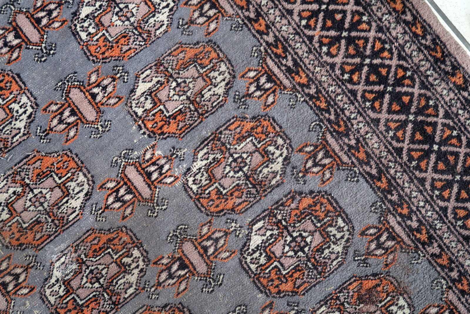 Handmade vintage Uzbek Bukhara rug in traditional design. The rug is from the end of 20th century made in wool. The rug is in original condition, has some low pile.