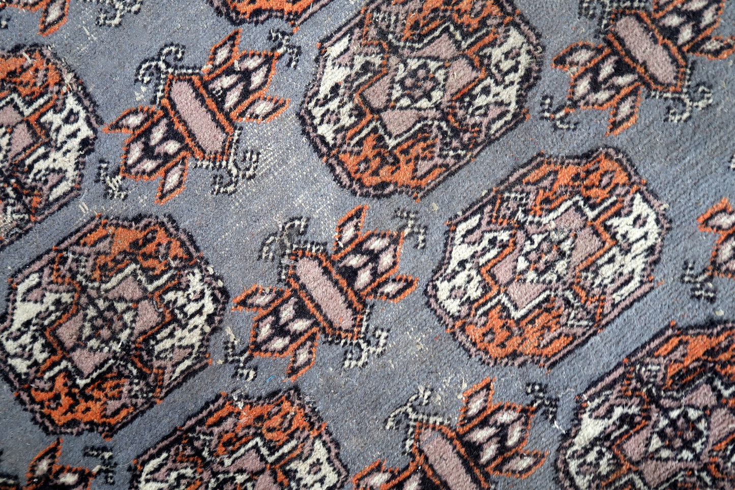 Handmade vintage Uzbek Bukhara rug in traditional design. The rug is from the end of 20th century made in wool. The rug is in original condition, has some low pile.