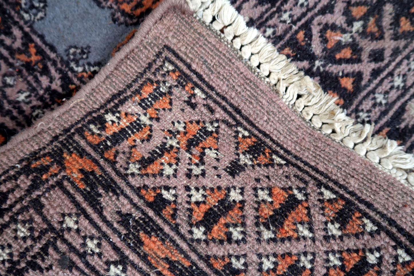 Handmade vintage Uzbek Bukhara rug in traditional design. The rug is from the end of 20th century made in wool. The rug is in original condition, has some low pile.