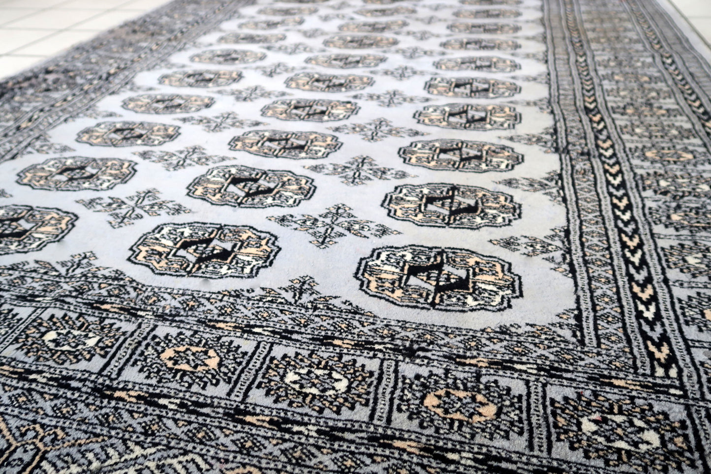 Handmade vintage Uzbek Bukhara rug in traditional design. The rug is from the end of 20th century made in wool. The rug is in original condition, has some signs of age.