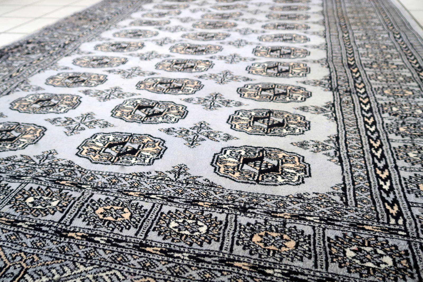 Handmade vintage Uzbek Bukhara rug in traditional design. The rug is from the end of 20th century made in wool. The rug is in original condition, has some signs of age.
