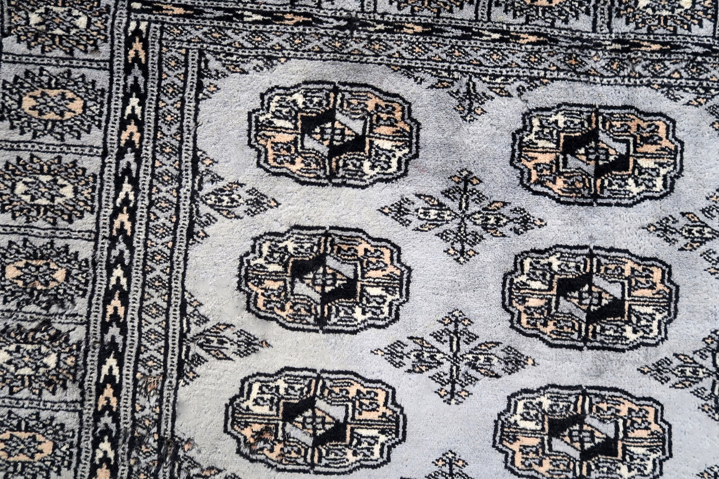 Handmade vintage Uzbek Bukhara rug in traditional design. The rug is from the end of 20th century made in wool. The rug is in original condition, has some signs of age.