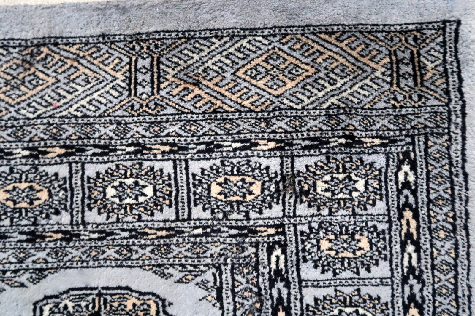 Handmade vintage Uzbek Bukhara rug in traditional design. The rug is from the end of 20th century made in wool. The rug is in original condition, has some signs of age.