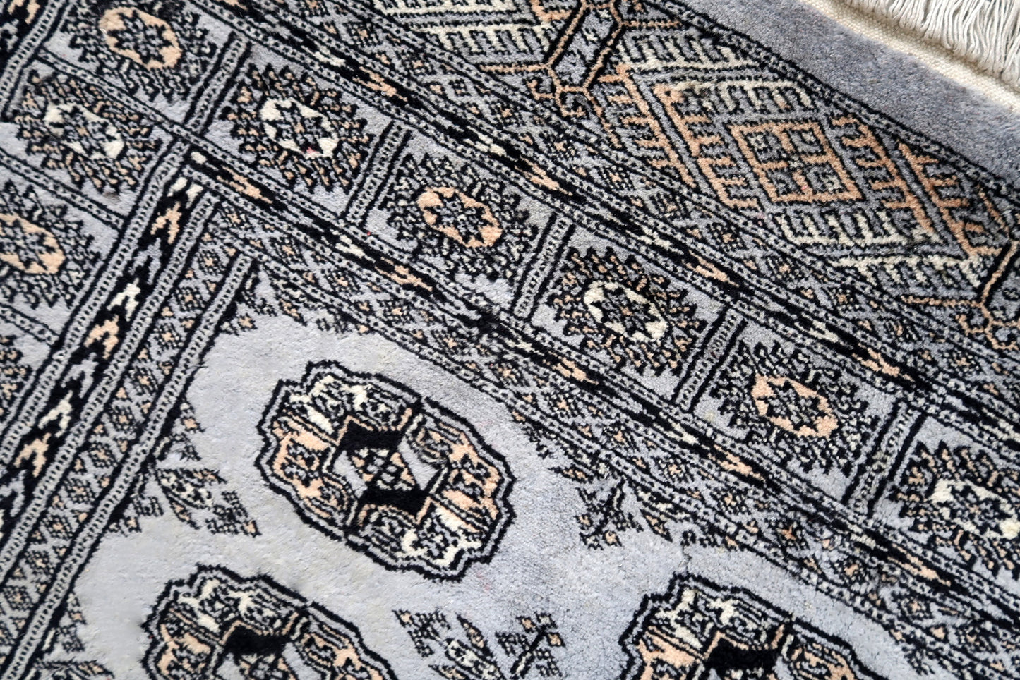 Handmade vintage Uzbek Bukhara rug in traditional design. The rug is from the end of 20th century made in wool. The rug is in original condition, has some signs of age.