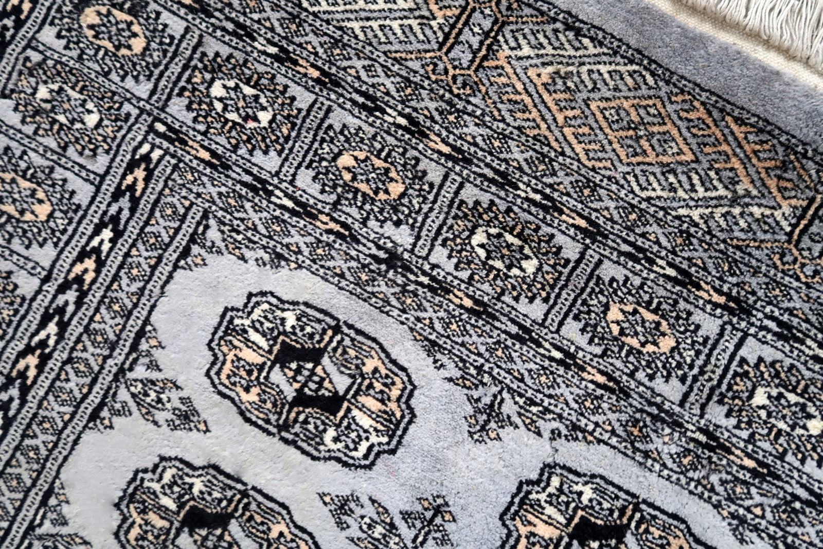 Handmade vintage Uzbek Bukhara rug in traditional design. The rug is from the end of 20th century made in wool. The rug is in original condition, has some signs of age.