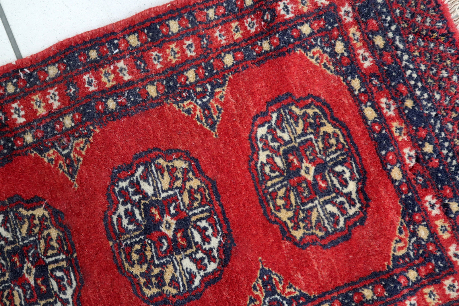 Handmade vintage Pakistani Lahore mat in traditional medallion design. The rug has been made in wool in the end of 20th century. It is in original good condition