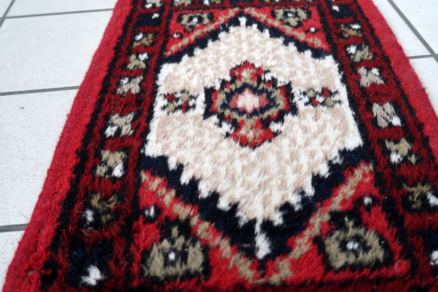Handmade vintage Middle Eastern rug in traditional medallion design. The rug has been made in wool in the end of 20th century. It is in original condition, has some low pile.