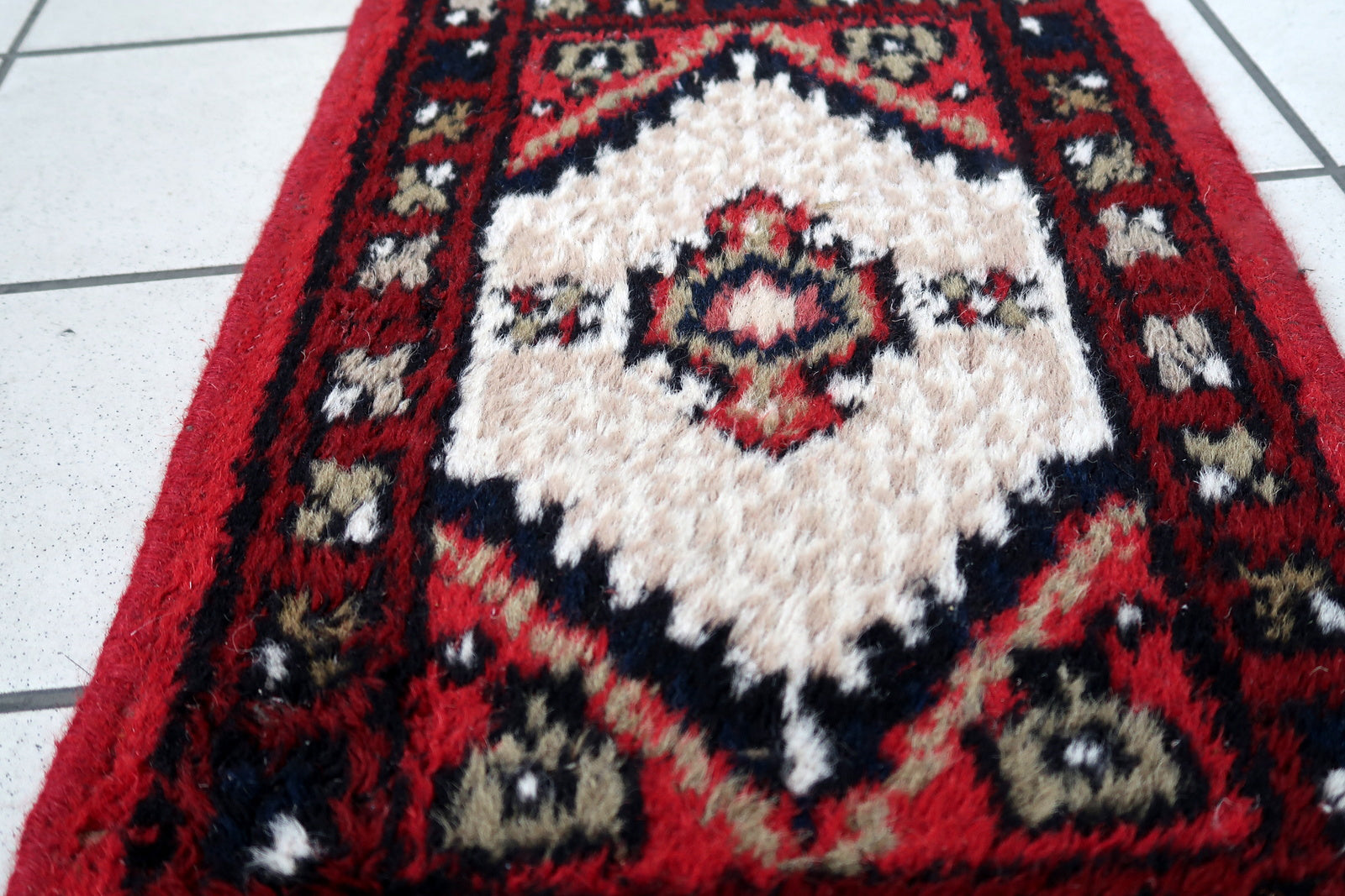 Handmade vintage Middle Eastern rug in traditional medallion design. The rug has been made in wool in the end of 20th century. It is in original condition, has some low pile.