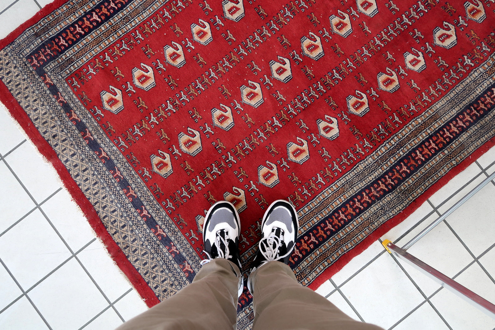 Handmade vintage Uzbek Bukhara rug in red color. The rug has been made in wool in the middle of 20th century. It is in original condition, it has some low pile.