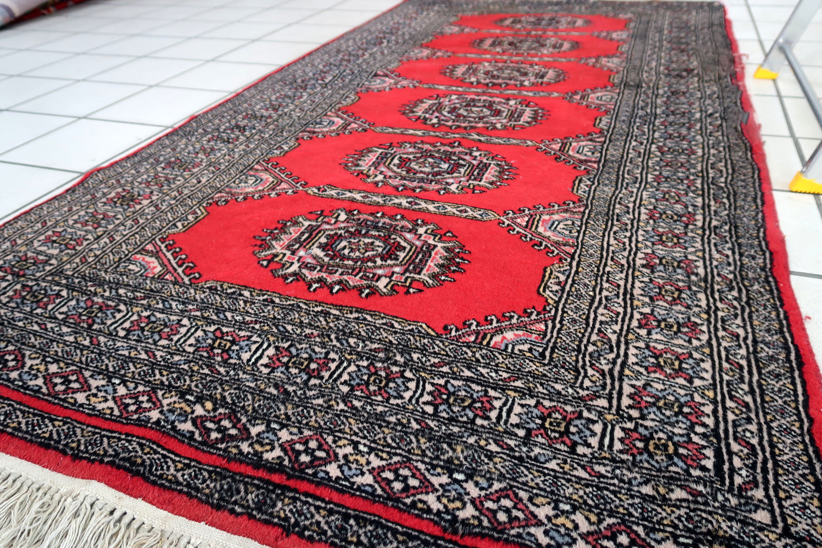 Handmade vintage Uzbek Bukhara rug in red color. The rug has been made in wool in the end of 20th century. It is in original condition, it has some signs of age.