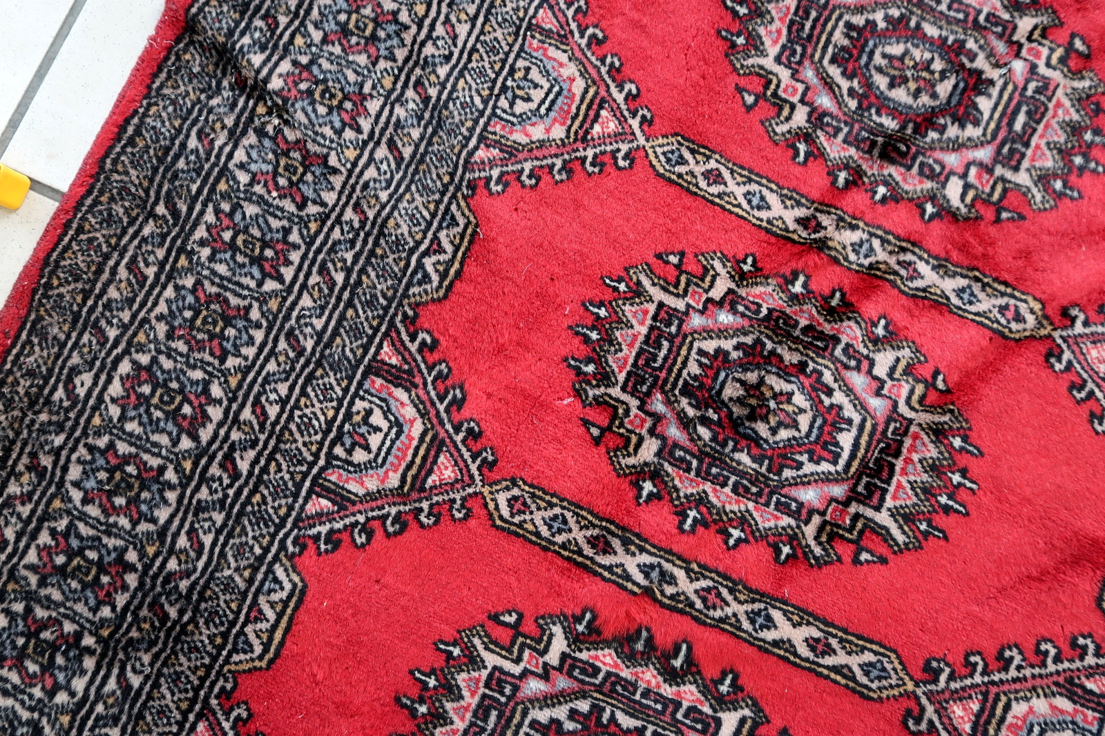 Handmade vintage Uzbek Bukhara rug in red color. The rug has been made in wool in the end of 20th century. It is in original condition, it has some signs of age.