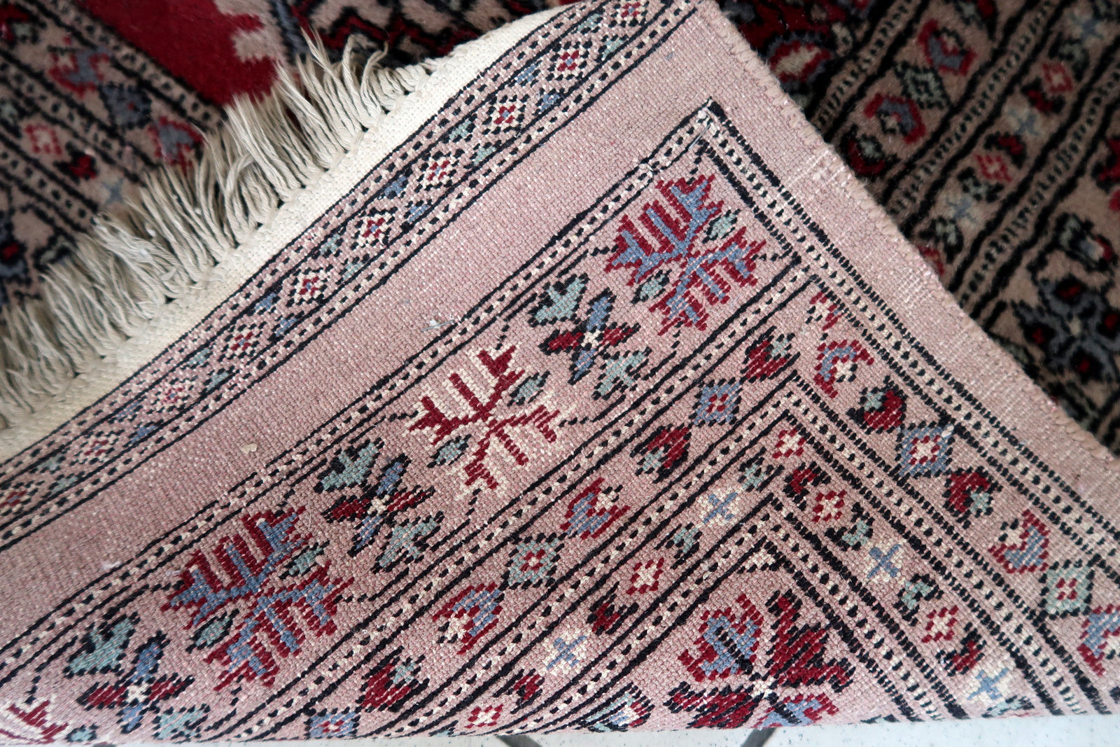 Handmade vintage Uzbek Bukhara rug in red color. The rug has been made in wool in the end of 20th century. It is in original condition, it has some signs of age.