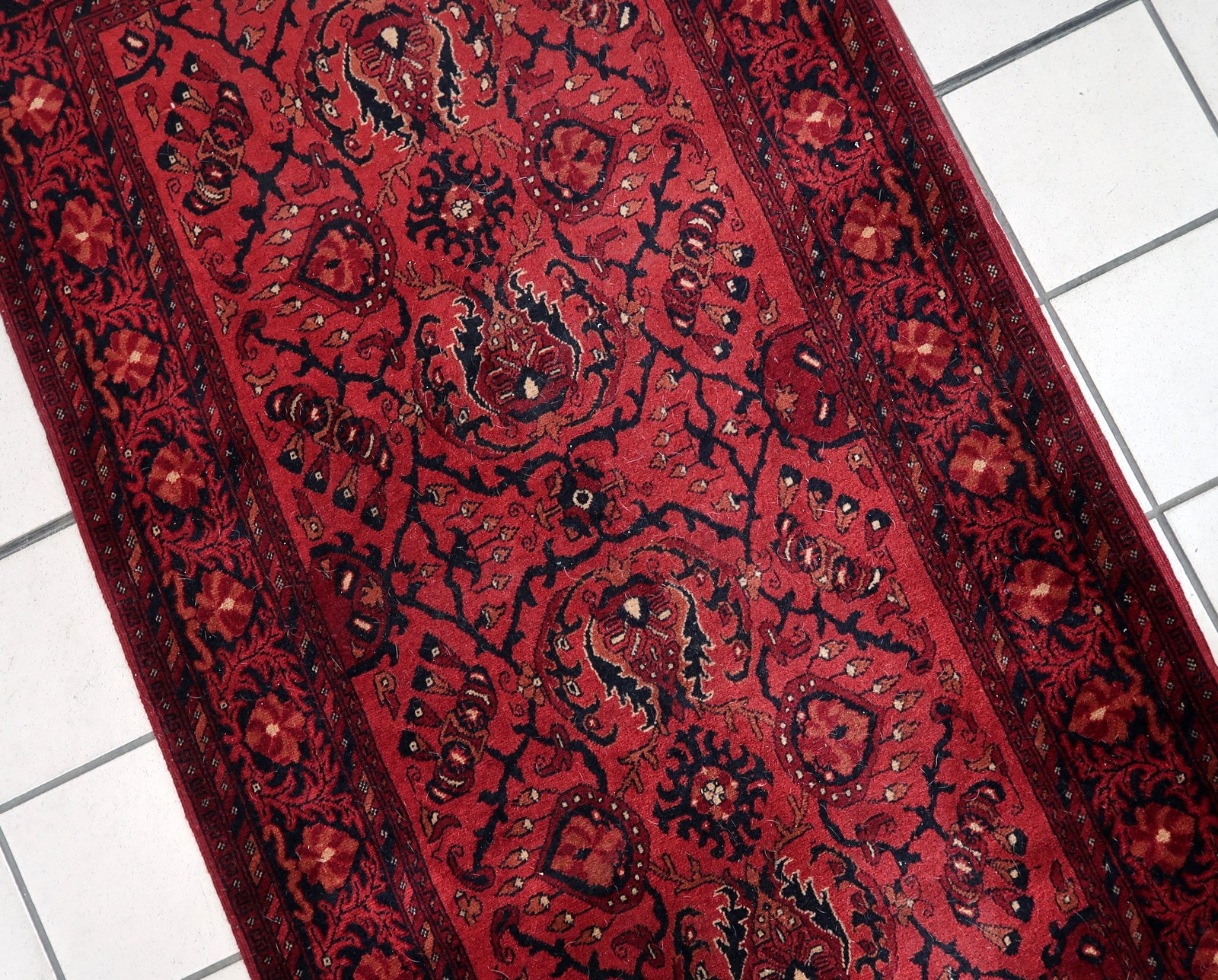 Handmade vintage Afghan Ersari runner in red color. The rug has been made in wool in the end of 20th century. It is in original good condition.