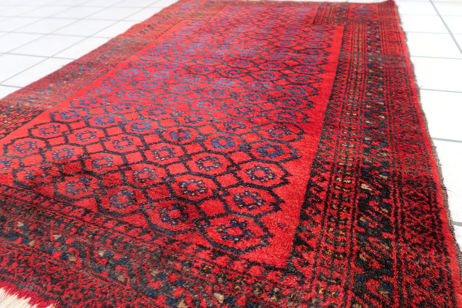 Handmade vintage Afghan Baluch rug in red color and prayer design. The rug has been made in wool in the middle of 20th century. It is in original good condition.