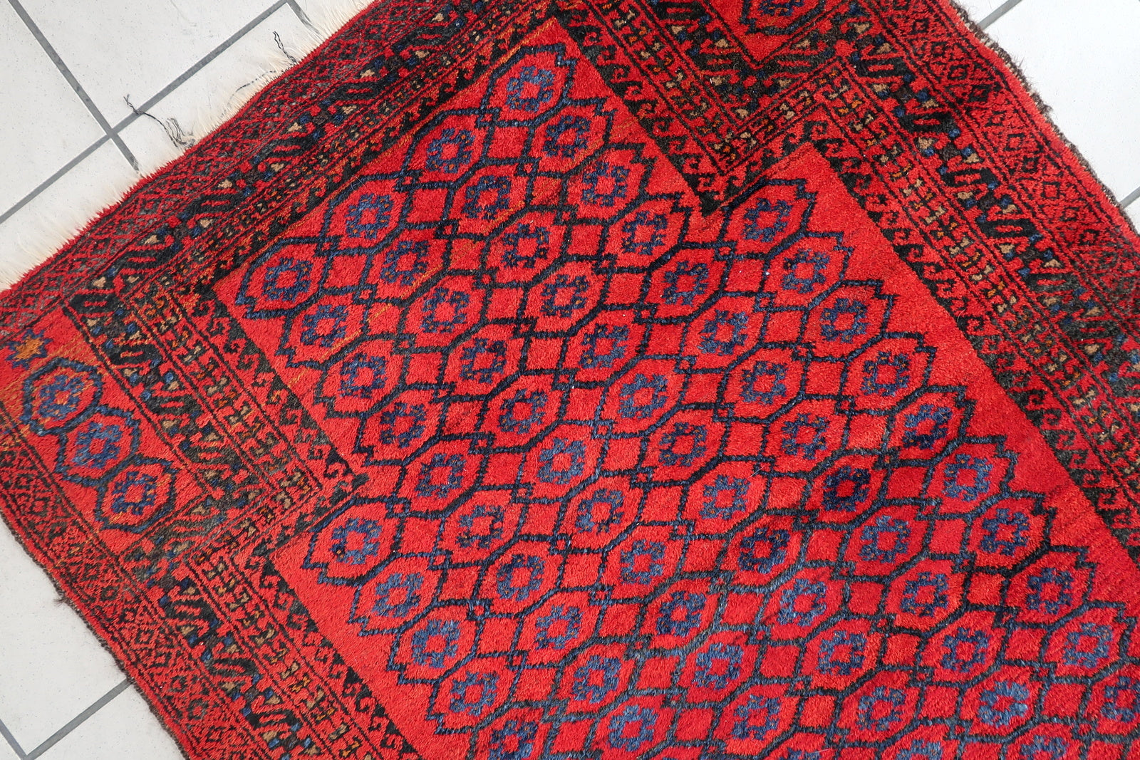 Handmade vintage Afghan Baluch rug in red color and prayer design. The rug has been made in wool in the middle of 20th century. It is in original good condition.