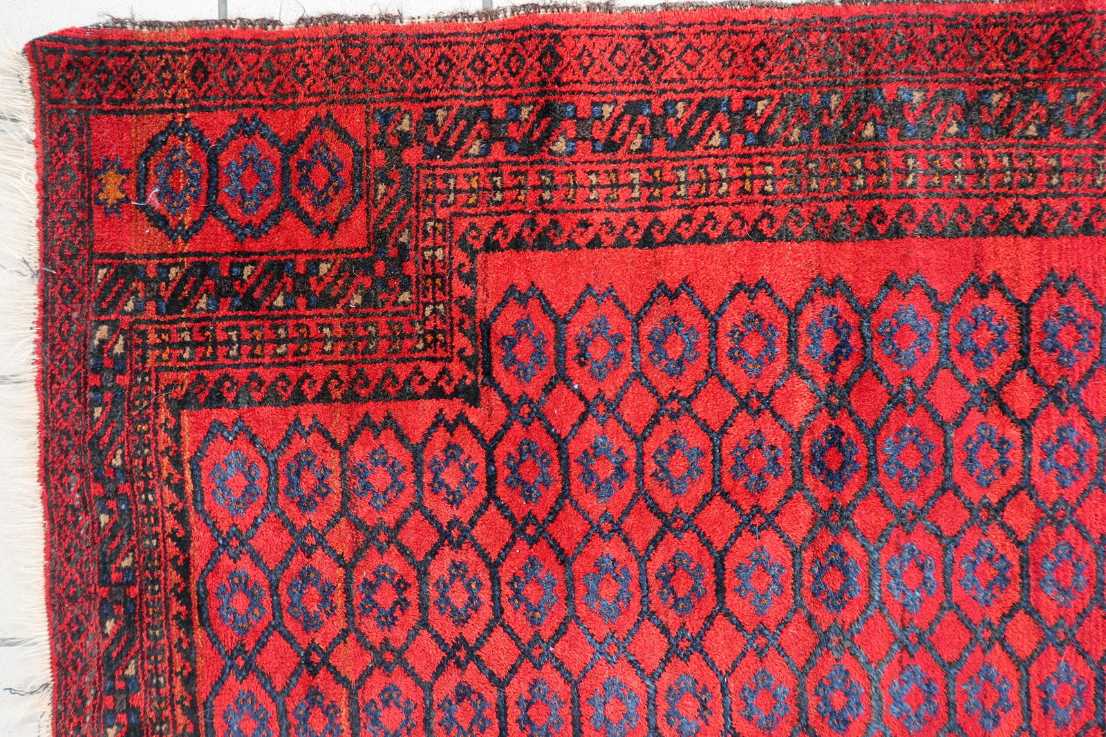 Handmade vintage Afghan Baluch rug in red color and prayer design. The rug has been made in wool in the middle of 20th century. It is in original good condition.