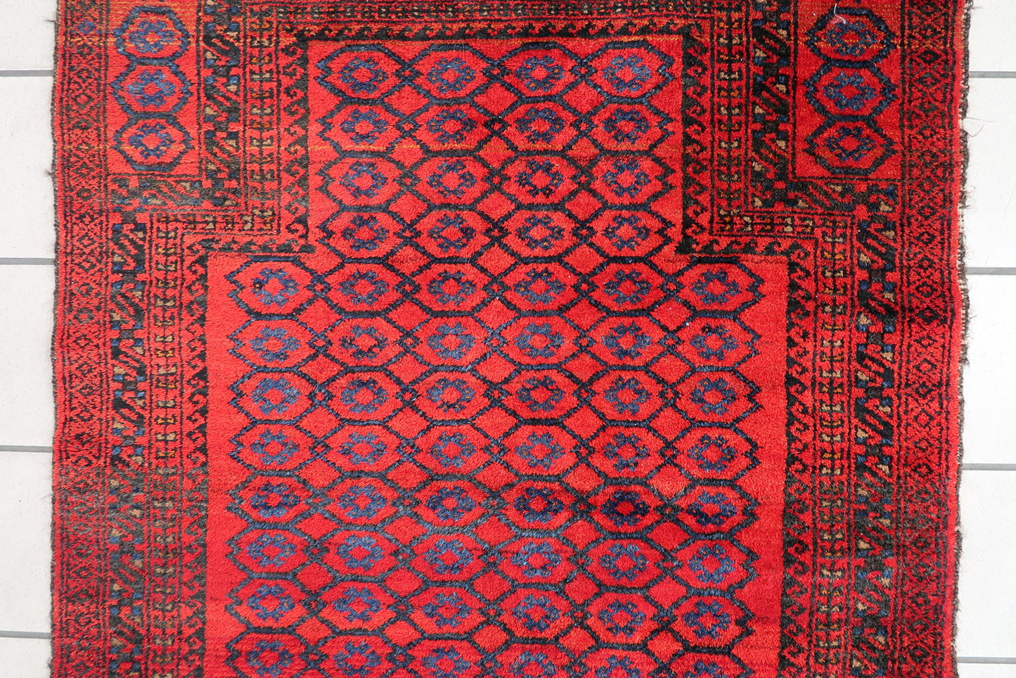 Handmade vintage Afghan Baluch rug in red color and prayer design. The rug has been made in wool in the middle of 20th century. It is in original good condition.
