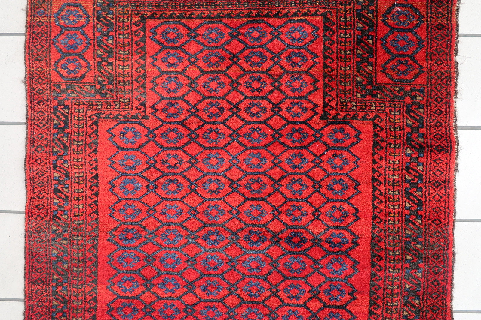 Handmade vintage Afghan Baluch rug in red color and prayer design. The rug has been made in wool in the middle of 20th century. It is in original good condition.