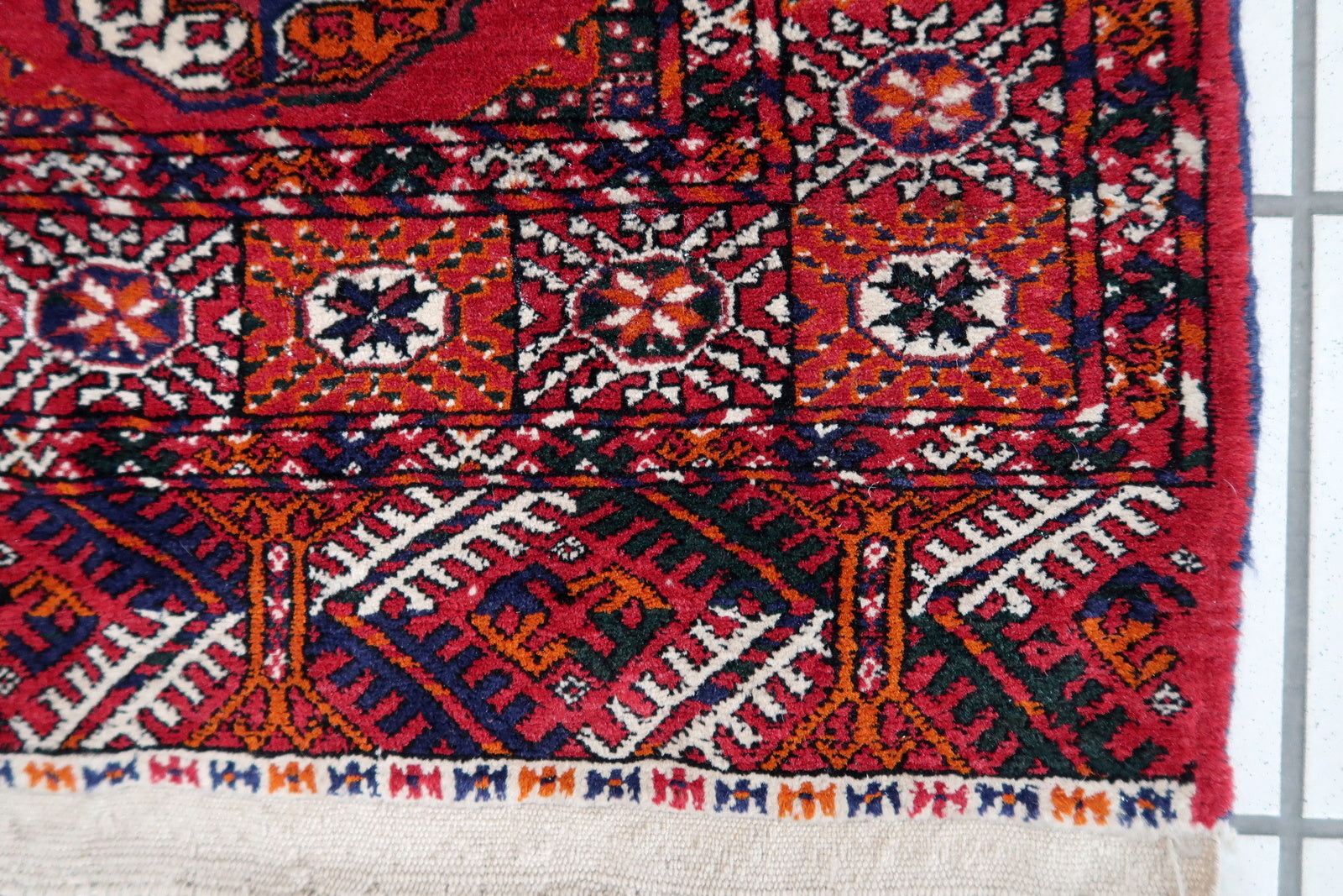 Handmade vintage Turkmen Tekke rug in wool and traditional design. The rug is from the end of 20th century in original good condition. The sides of the rug are not even.
