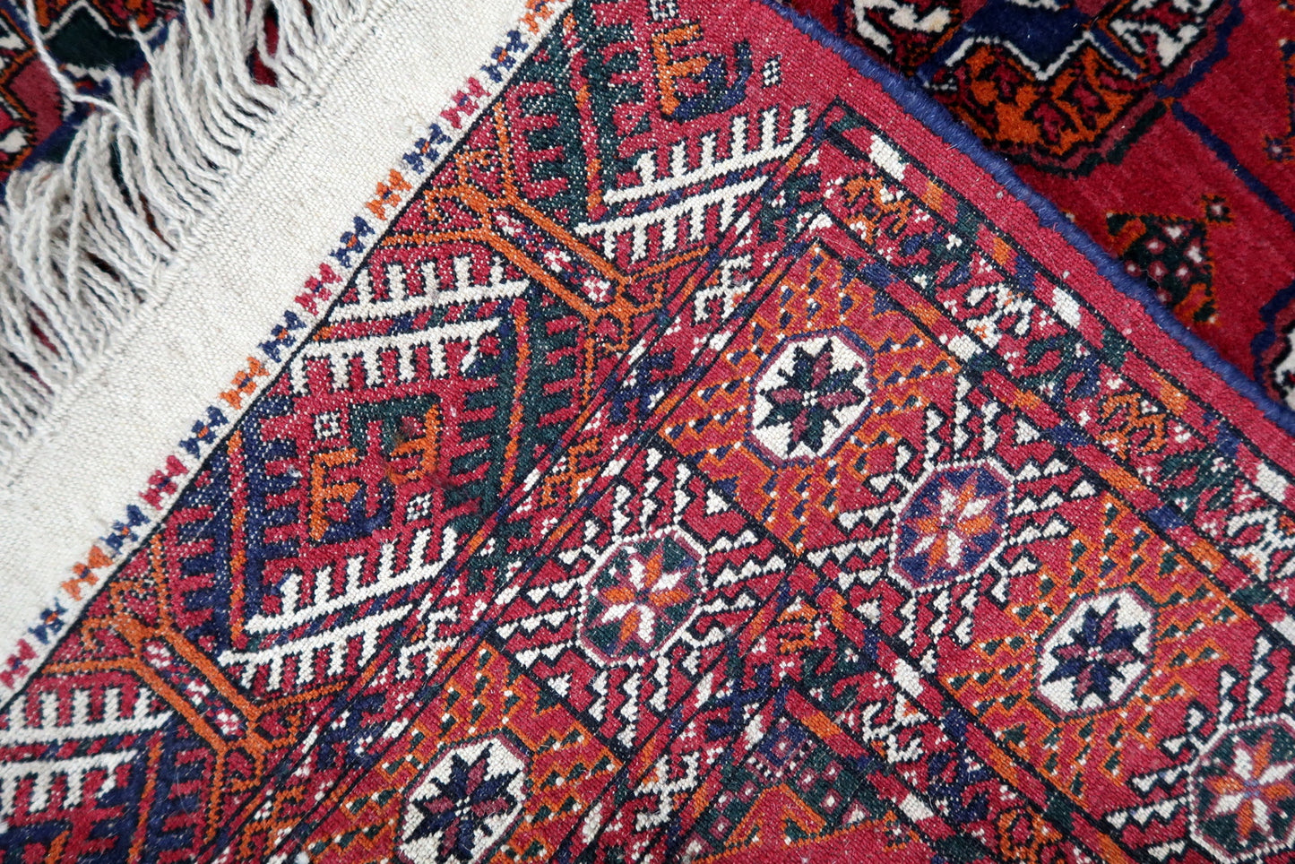 Handmade vintage Turkmen Tekke rug in wool and traditional design. The rug is from the end of 20th century in original good condition. The sides of the rug are not even.