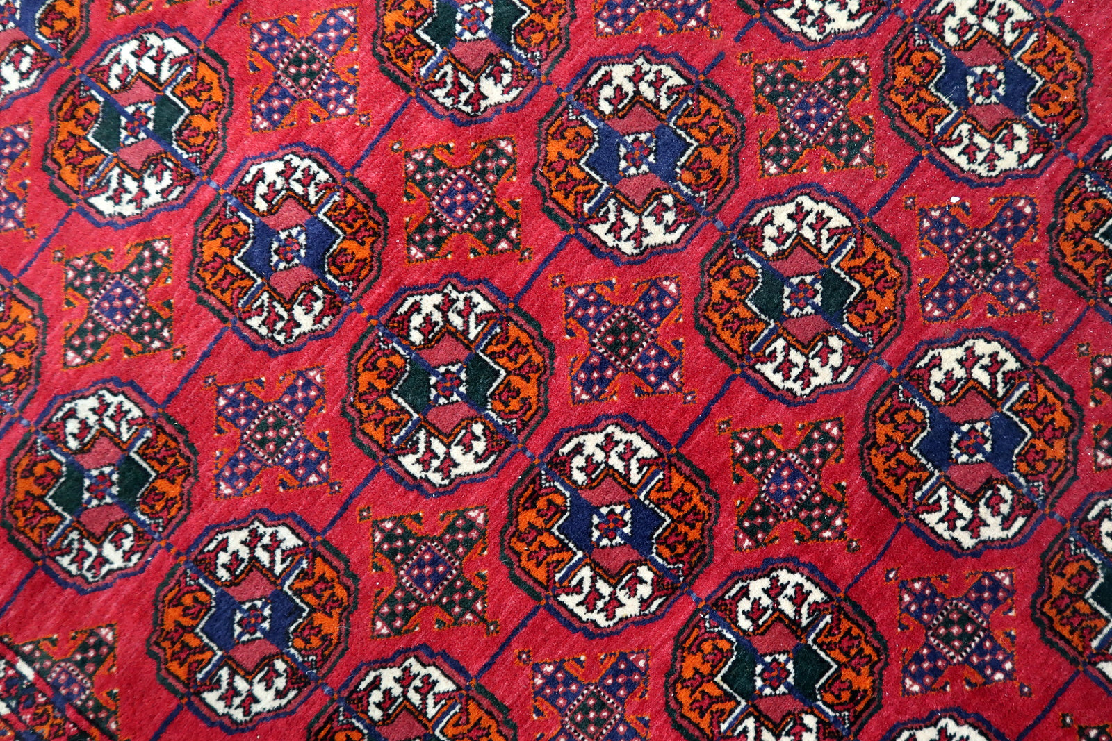Handmade vintage Turkmen Tekke rug in wool and traditional design. The rug is from the end of 20th century in original good condition. The sides of the rug are not even.