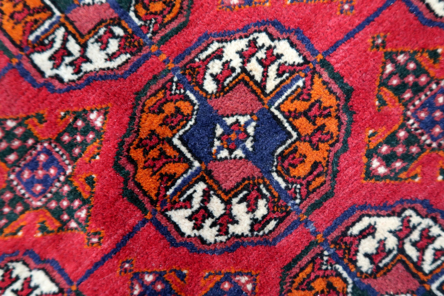 Handmade vintage Turkmen Tekke rug in wool and traditional design. The rug is from the end of 20th century in original good condition. The sides of the rug are not even.