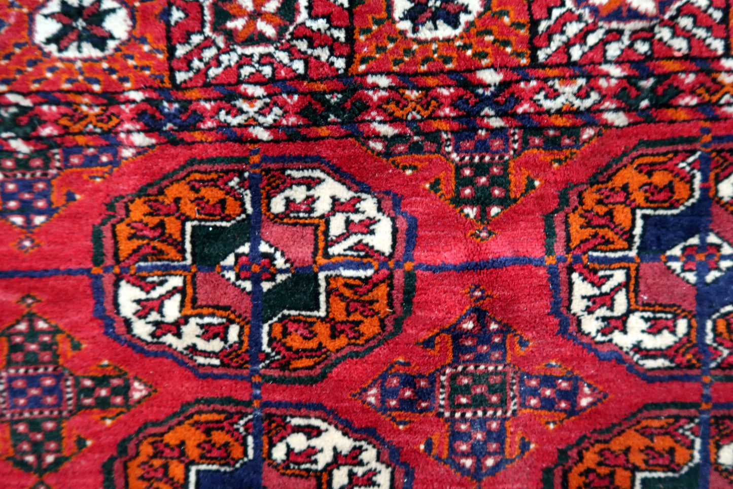 Handmade vintage Turkmen Tekke rug in wool and traditional design. The rug is from the end of 20th century in original good condition. The sides of the rug are not even.