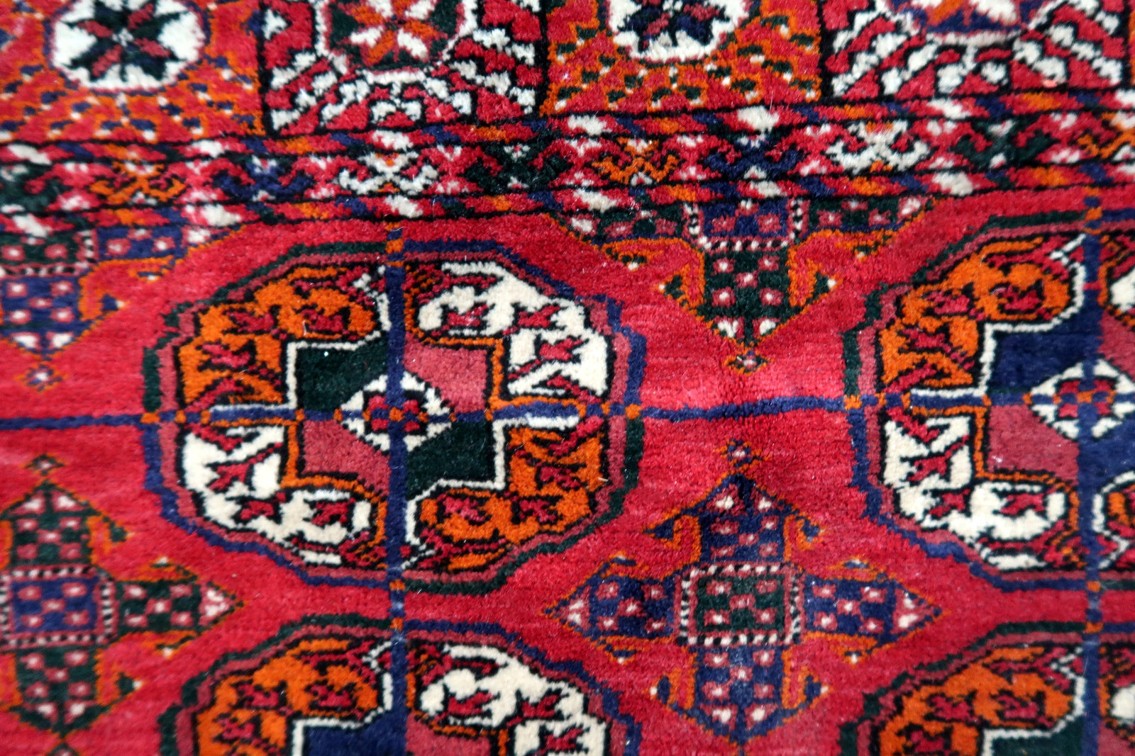 Handmade vintage Turkmen Tekke rug in wool and traditional design. The rug is from the end of 20th century in original good condition. The sides of the rug are not even.