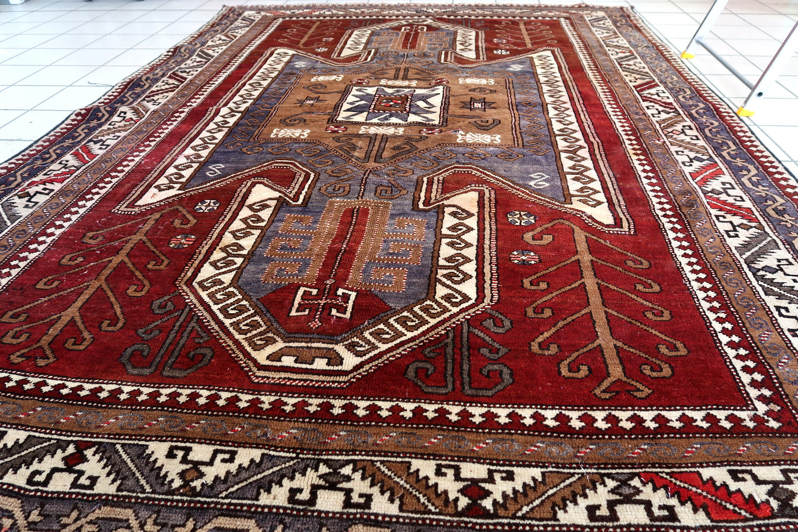 Handmade vintage Caucasian Kazak rug deep red color and large medallion. The rug is from the beginning of 20th century, it is in good condition. 