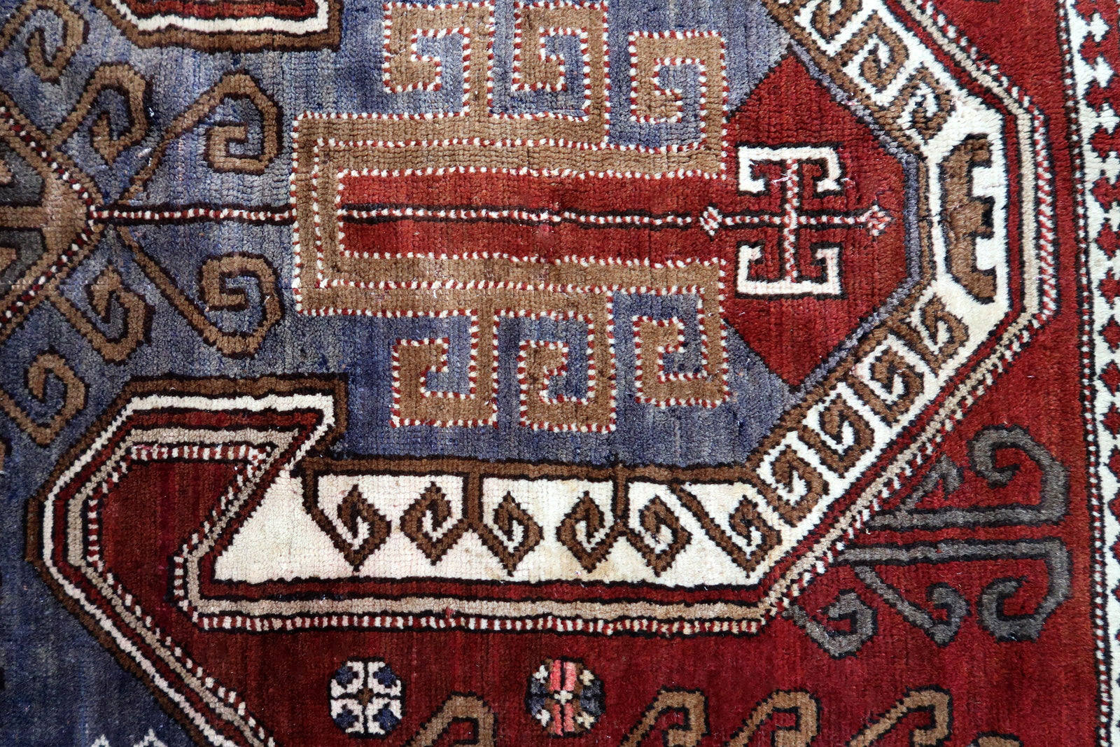 Handmade vintage Caucasian Kazak rug deep red color and large medallion. The rug is from the beginning of 20th century, it is in good condition. 