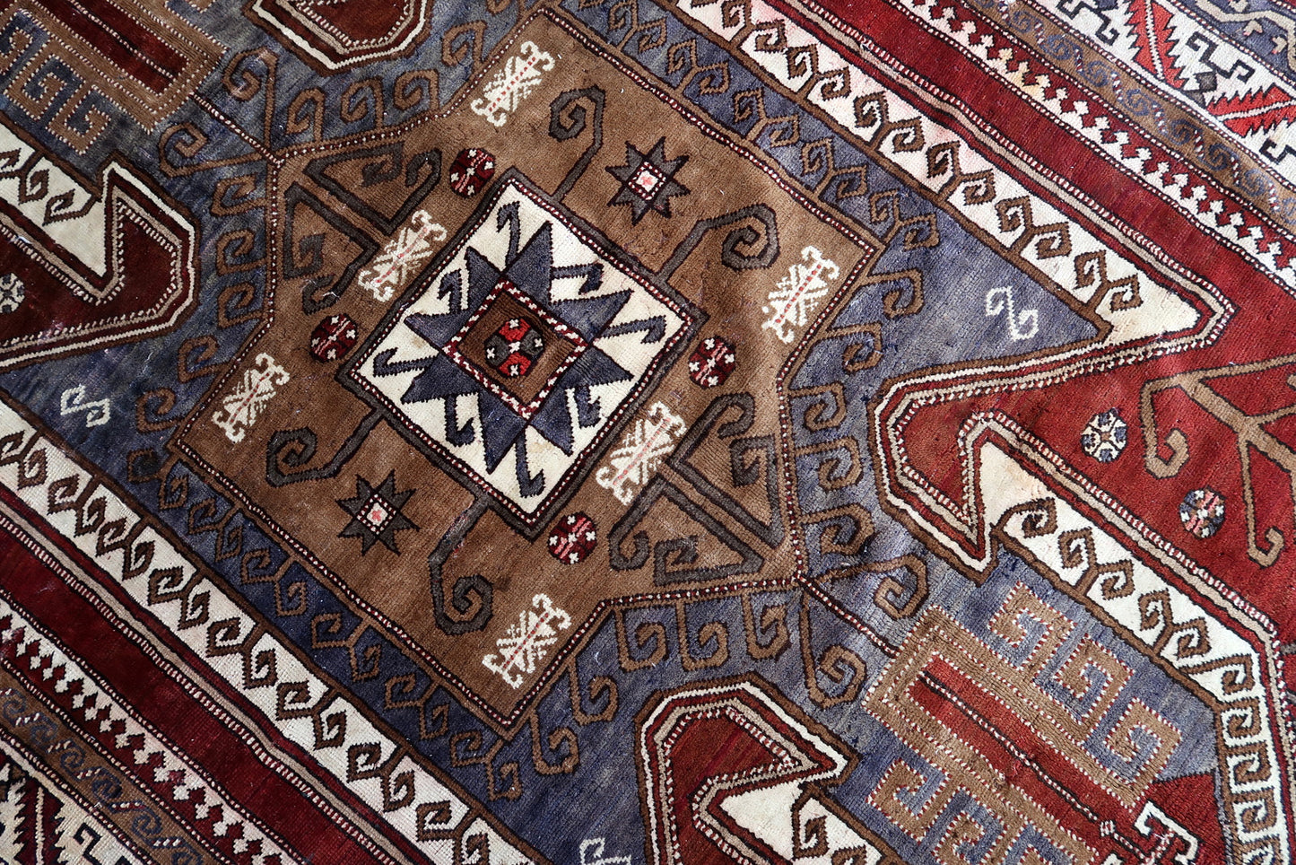 Handmade vintage Caucasian Kazak rug deep red color and large medallion. The rug is from the beginning of 20th century, it is in good condition. 