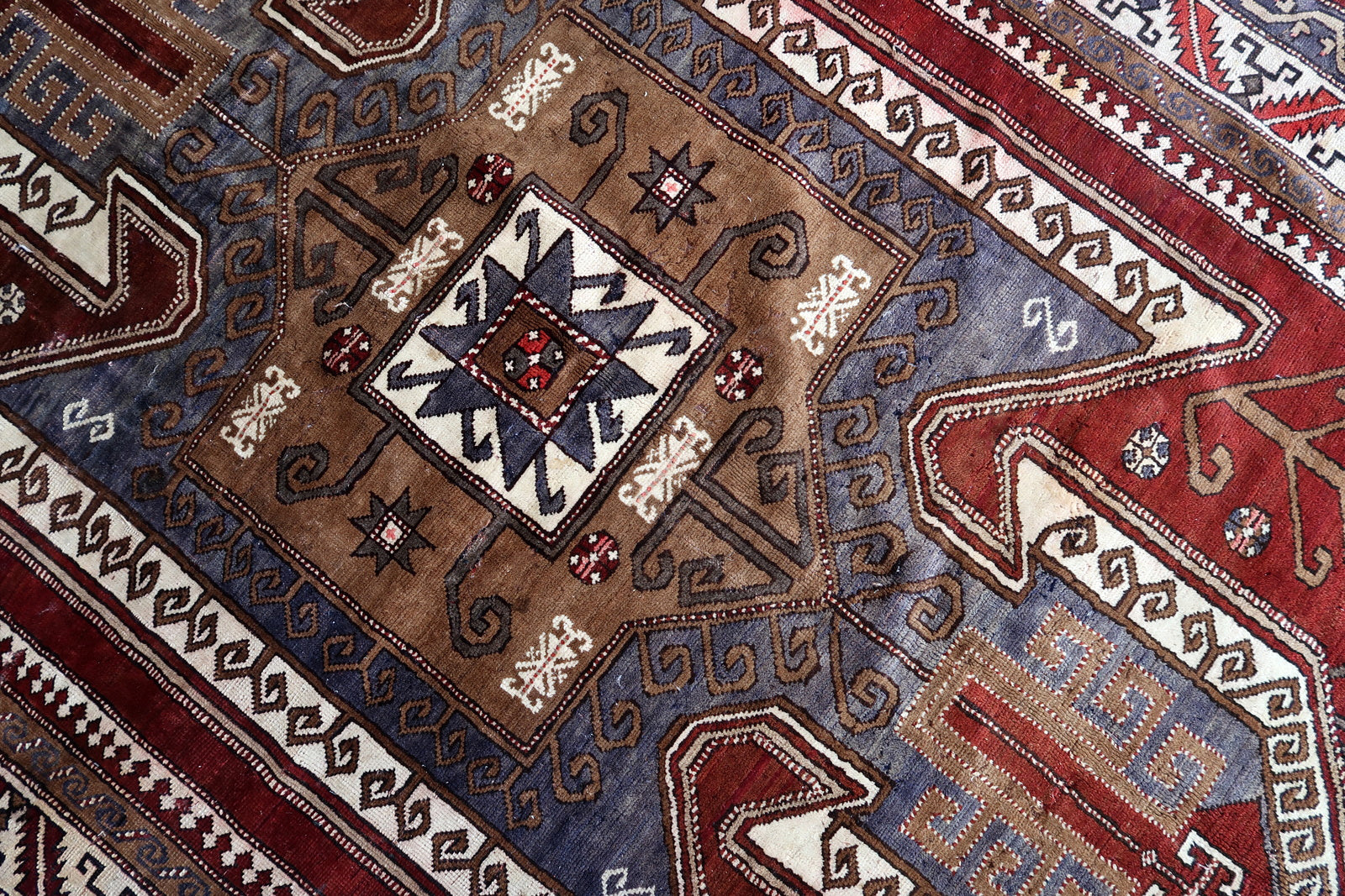 Handmade vintage Caucasian Kazak rug deep red color and large medallion. The rug is from the beginning of 20th century, it is in good condition. 