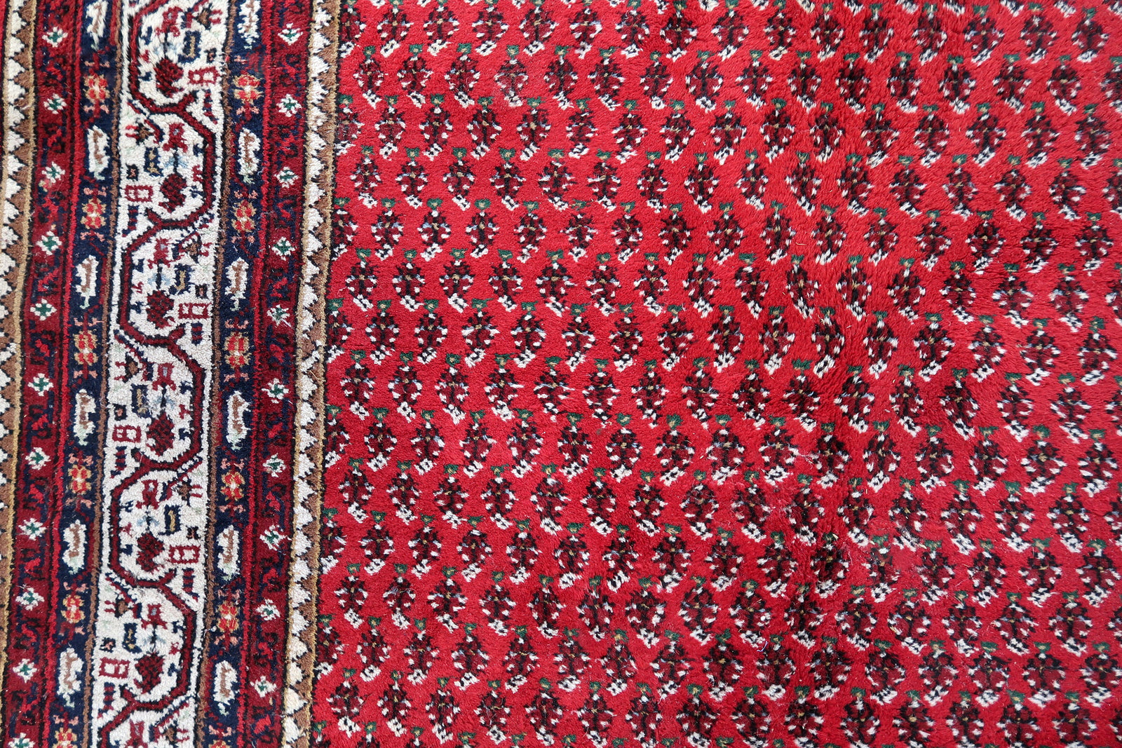 Handmade vintage Indian Seraband rug in original condition, it has some age wear on the one end. The rug has been made in traditional pattern, it is from end of 20th century. The shades of the rug are mostly in red and white. All-over design will bring some modern look to your space. All dyes on this rug are natural. This is the type of rug woven in India to compete in the same market as rugs from Persia.