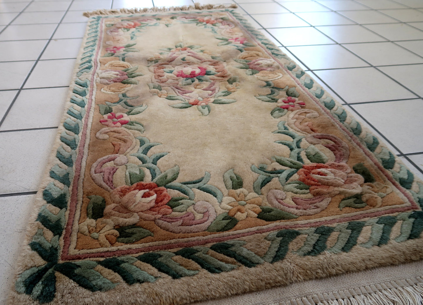 Handmade vintage Art Deco Chinese rug in beige, green and red colors. The rug is from the end of 20th century in original good condition. This rug has classic floral design with the touch of French style.