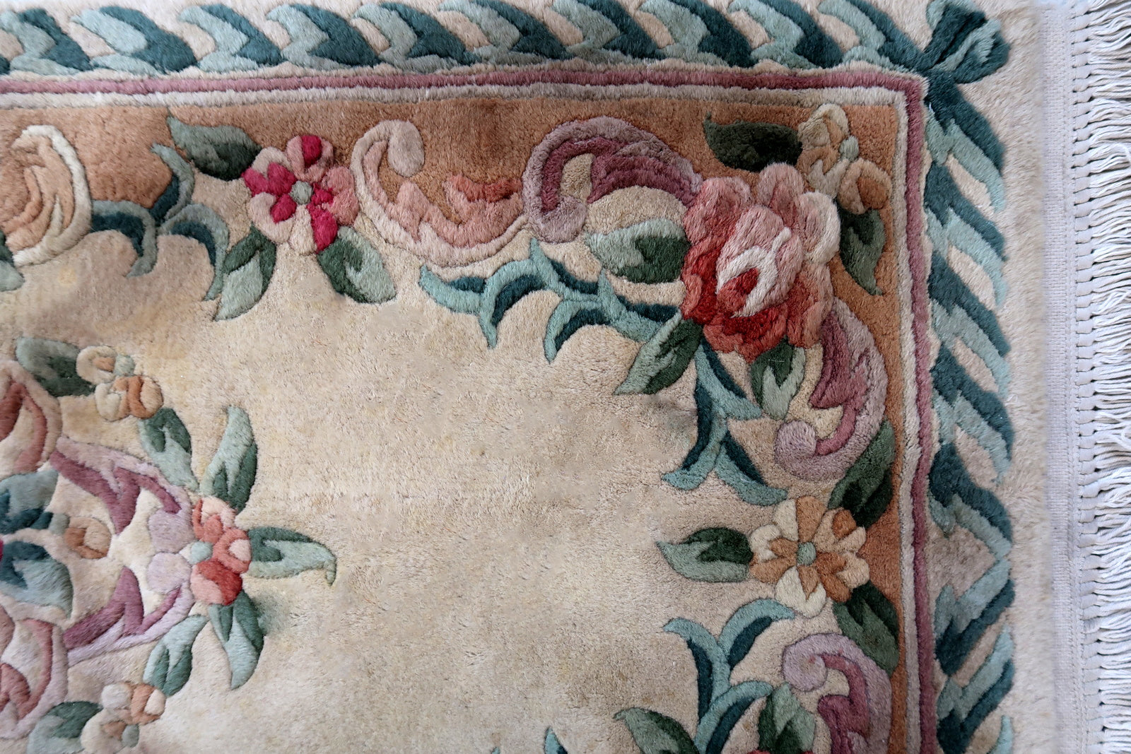 Handmade vintage Art Deco Chinese rug in beige, green and red colors. The rug is from the end of 20th century in original good condition. This rug has classic floral design with the touch of French style.
