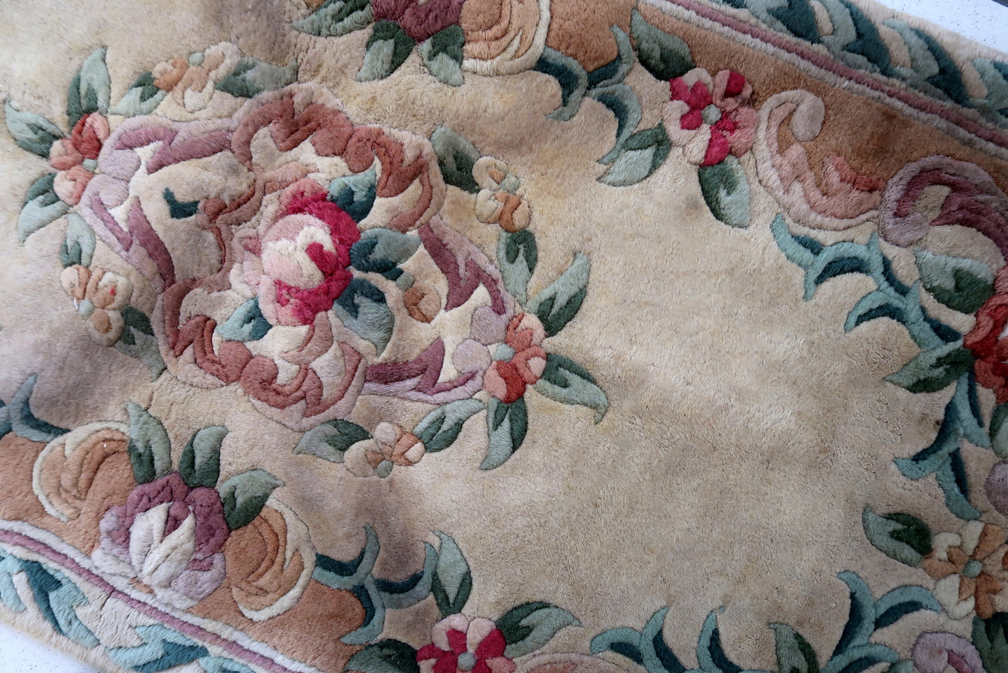Handmade vintage Art Deco Chinese rug in beige, green and red colors. The rug is from the end of 20th century in original good condition. This rug has classic floral design with the touch of French style.