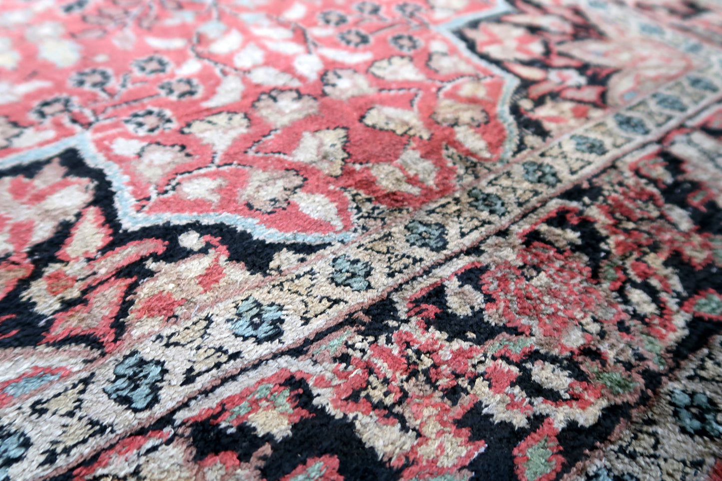 Handmade vintage Persian Tabriz rug made in Kashmir wool. The rug is from the end of 20th century in original good condition. The rug is in traditional medallion design in pink and black colors. Like many recent Tabrizes, this example shows floral figures drawn in a manner suggestive of Safavid art.