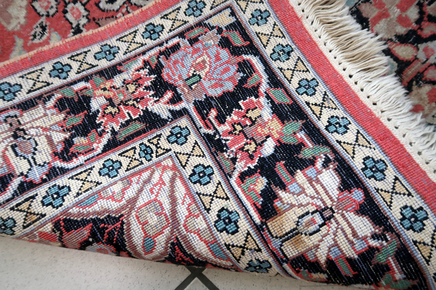 Handmade vintage Persian Tabriz rug made in Kashmir wool. The rug is from the end of 20th century in original good condition. The rug is in traditional medallion design in pink and black colors. Like many recent Tabrizes, this example shows floral figures drawn in a manner suggestive of Safavid art.