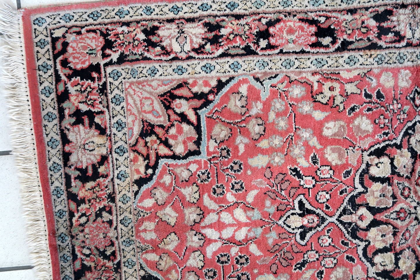 Handmade vintage Persian Tabriz rug made in Kashmir wool. The rug is from the end of 20th century in original good condition. The rug is in traditional medallion design in pink and black colors. Like many recent Tabrizes, this example shows floral figures drawn in a manner suggestive of Safavid art.