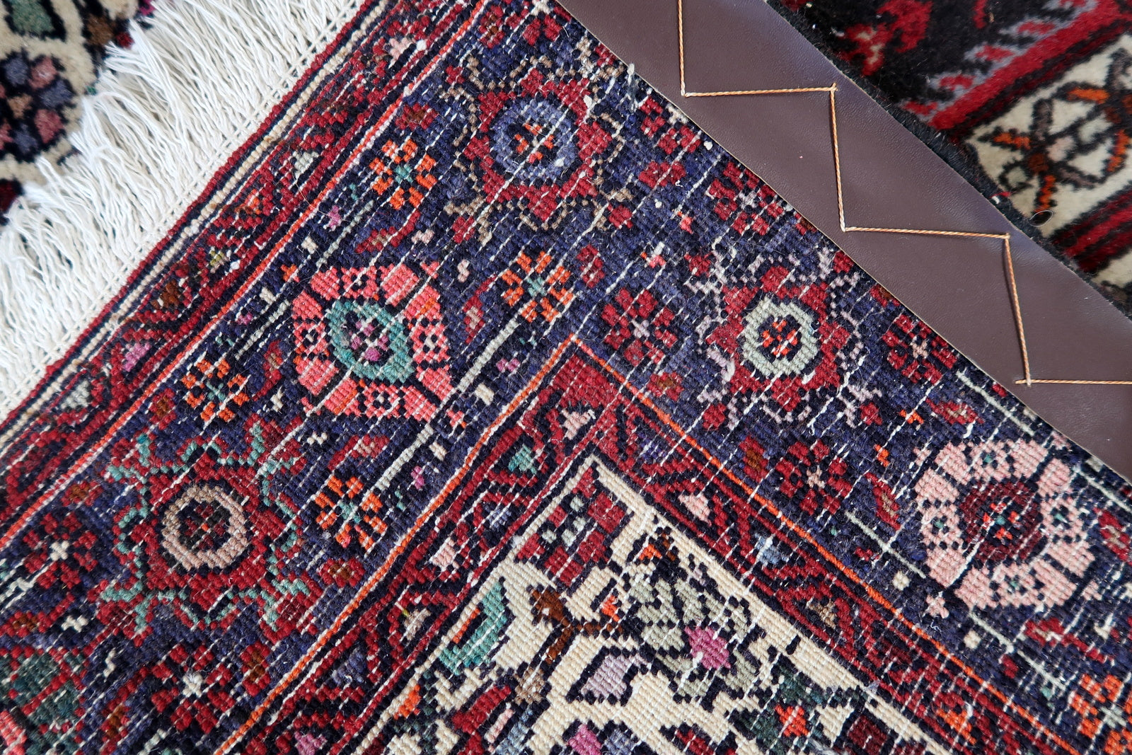 Handmade vintage Persian Bidjar woolen rug. The rug is from the end of 20th century, it is in original good condition. The rug is in traditional design with large medallion in the center. The color combination is white and red.
